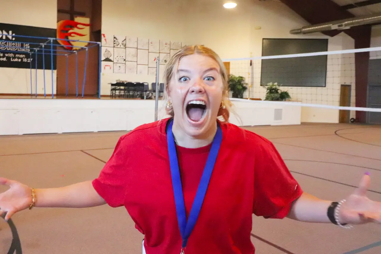 Young woman laughing with arms outstretched during a gym activity