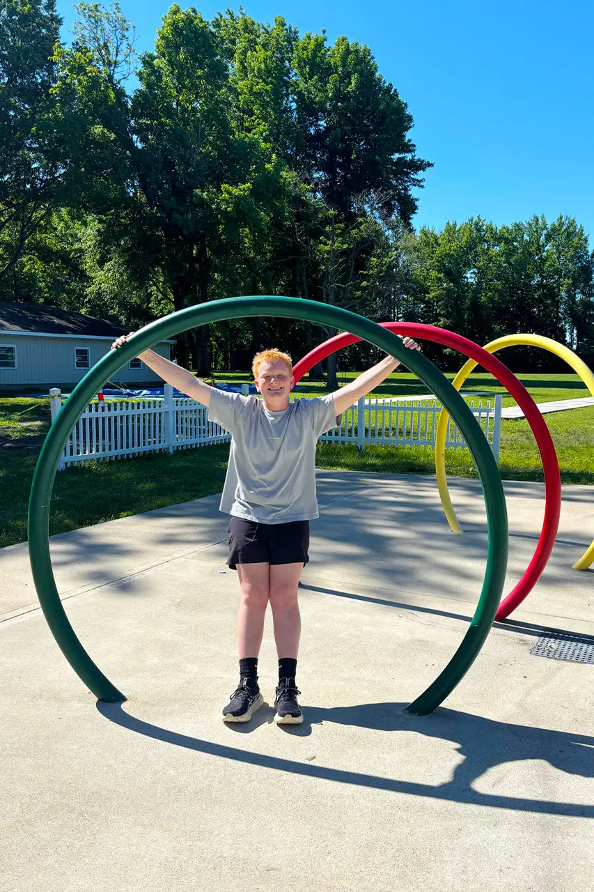 Camper climbing a rainbow-arc playground structure
