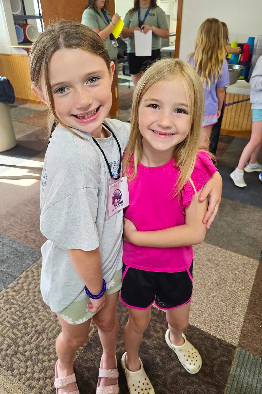 Two campers hugging indoors