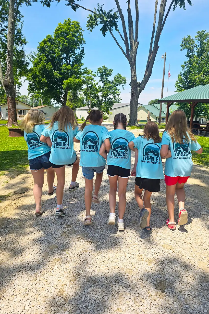 Line of campers walking arm in arm along a gravel path