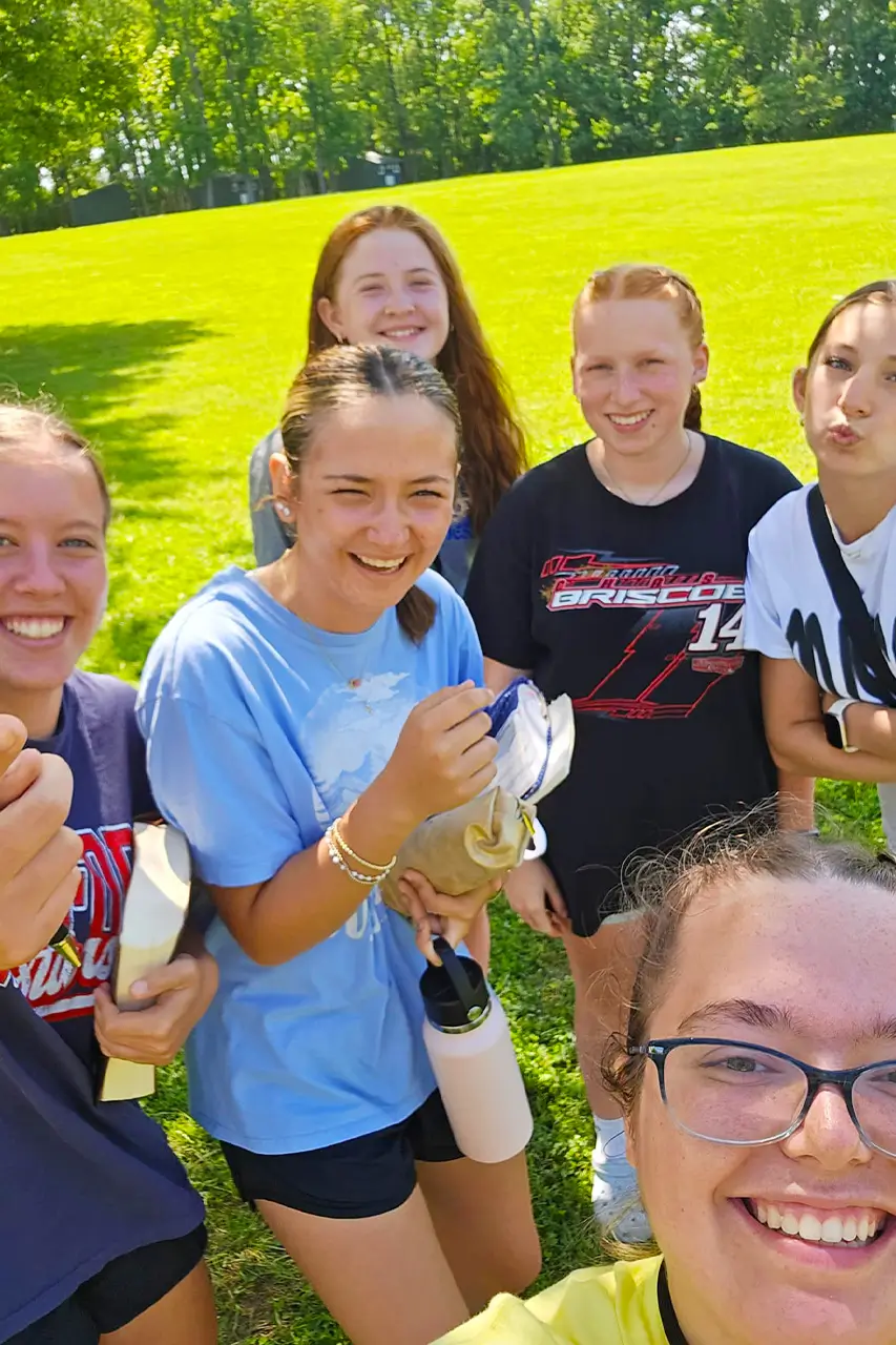 Group of girls taking a selfie outdoors on the grass